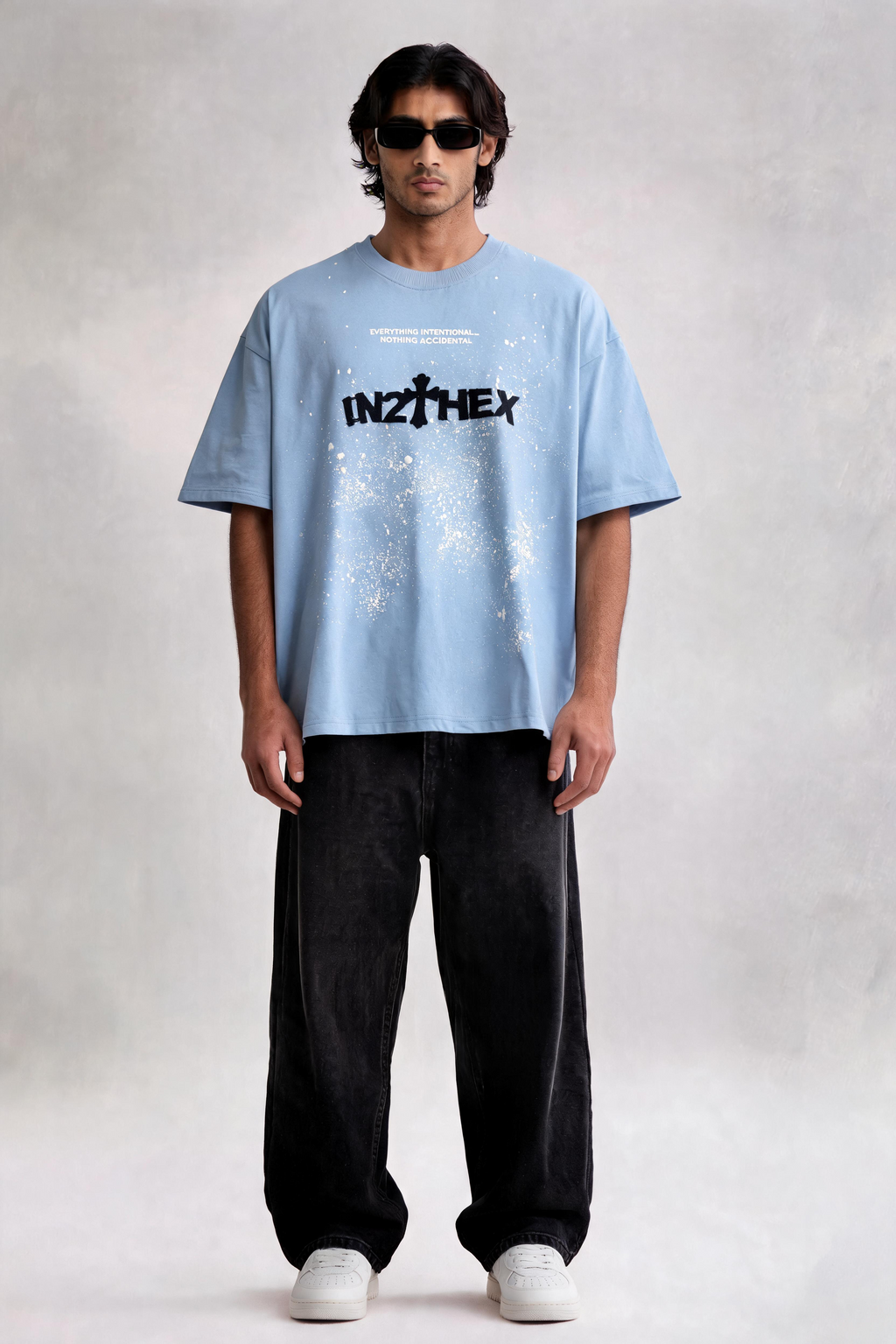 Man wearing a light blue t-shirt with 'INZITEX' logo on a plain background
