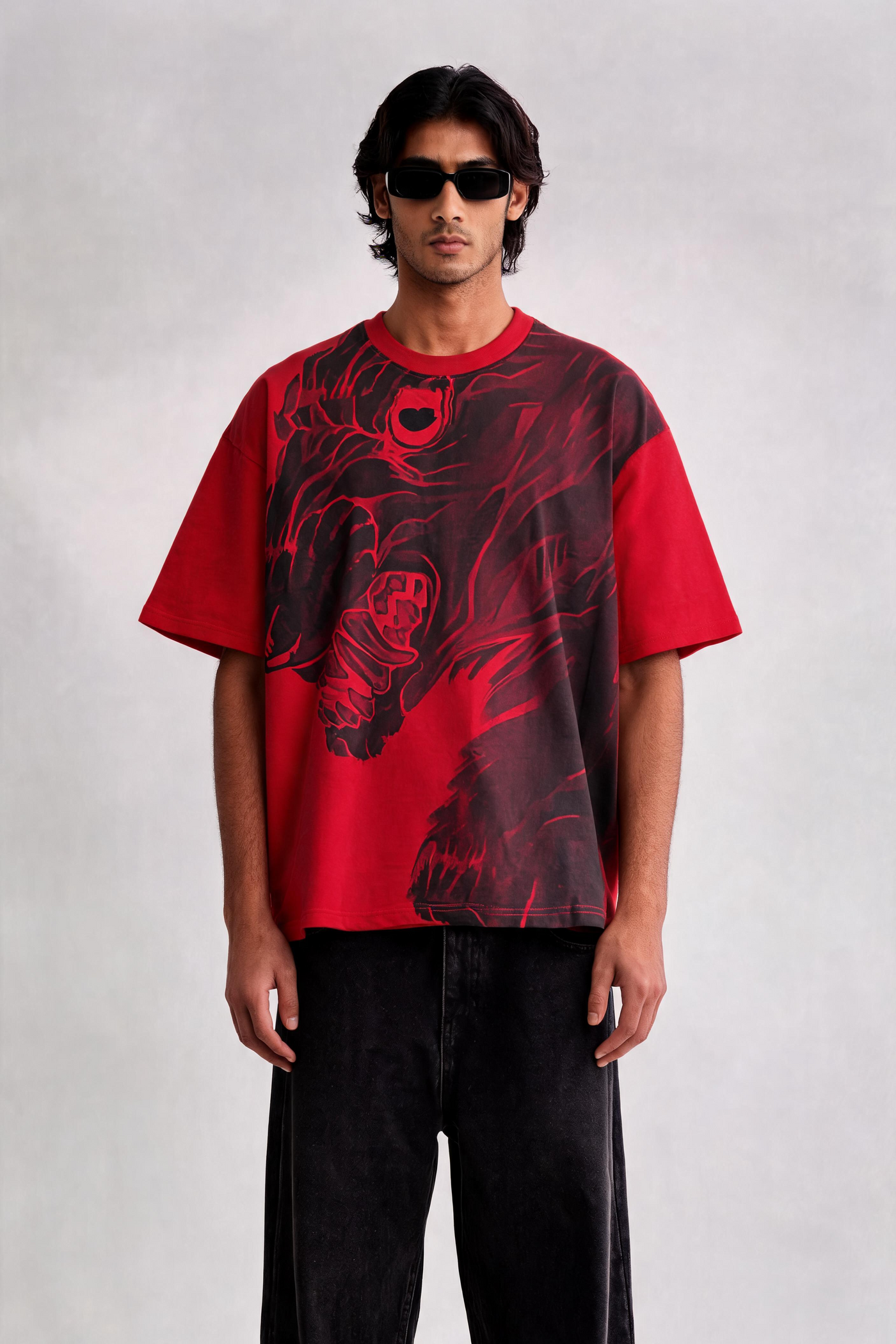 Person wearing a red graphic t-shirt and black pants on a white background