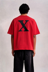 Person wearing a red t-shirt with a black 'X' on the back against a plain background