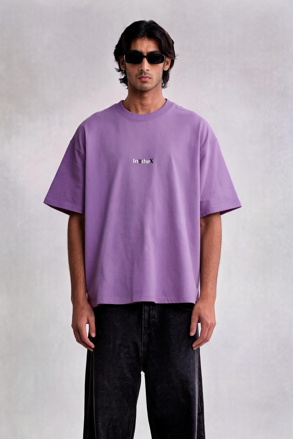 Person wearing a purple t-shirt and black pants on a white background