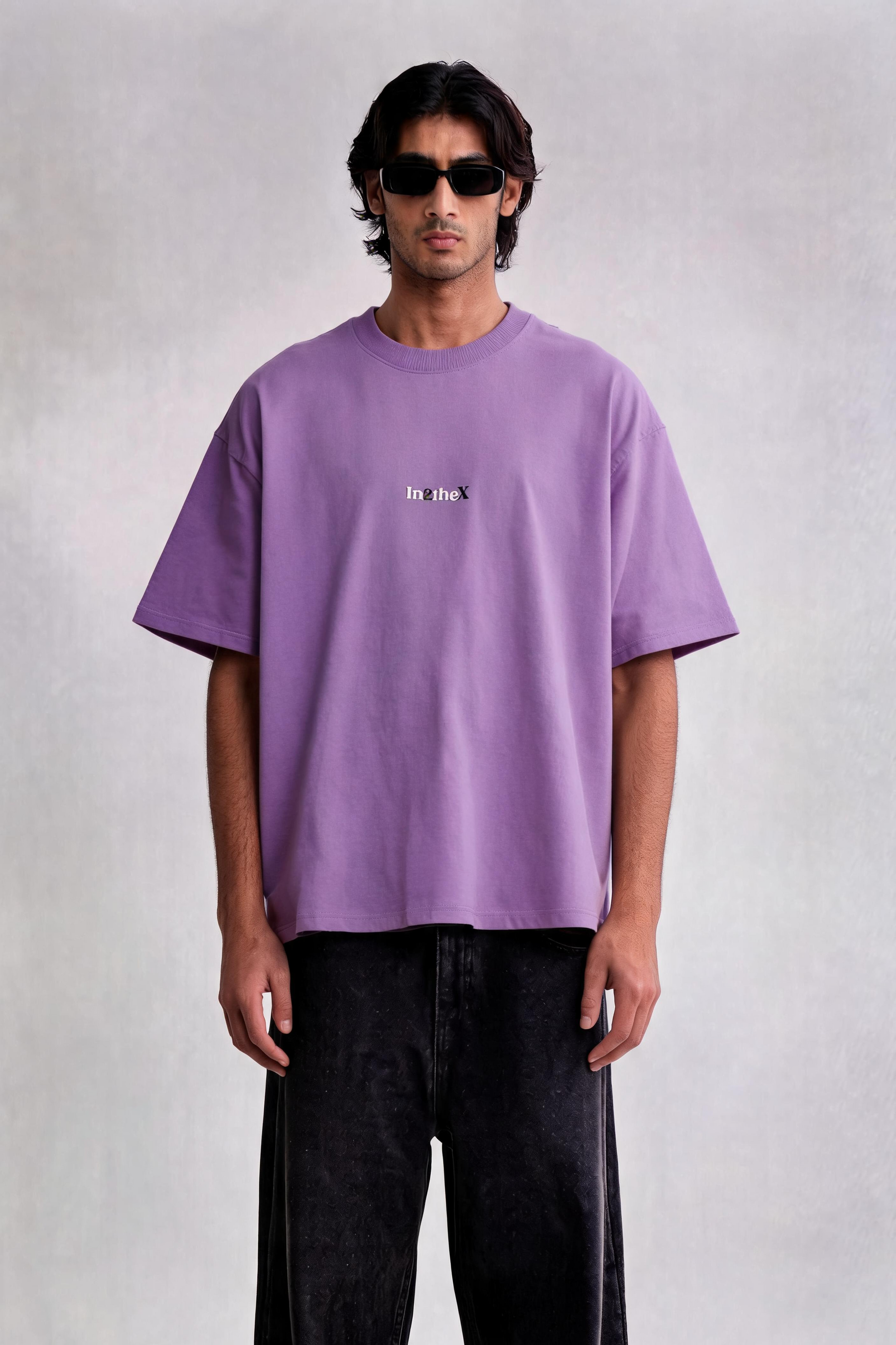 Person wearing a purple t-shirt and black pants on a white background