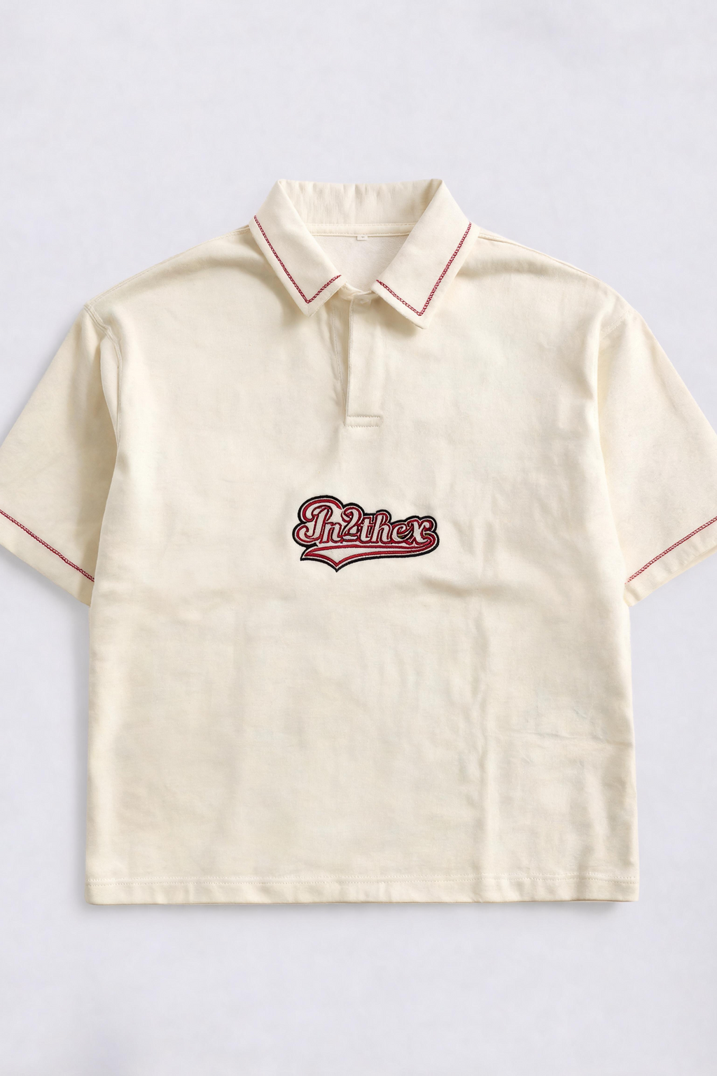 Beige polo shirt with red trim and embroidered logo on a light gray background