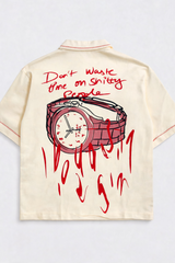 Beige shirt with red graphic of a watch and text on a light gray background